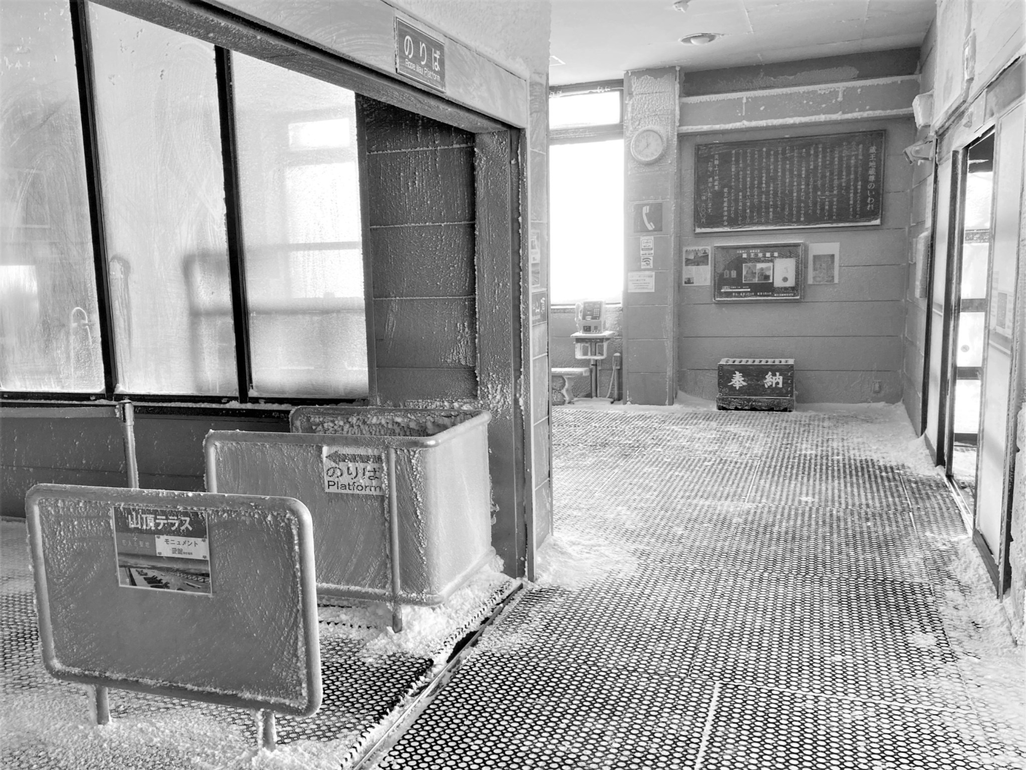 The frozen platform of a Japanese mountain ropeway station in the bright light of morning.